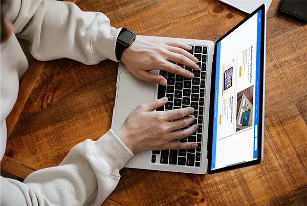 Person typing on a laptop displaying a multimedia video platform webpage, showcasing options to maximize creativity, create a marketplace, and explore digital content creation opportunities.